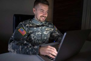Military guy in front of a computer